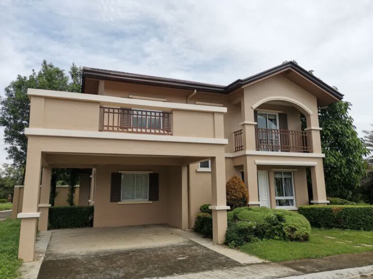 Rumah 2 lantai modern type 60 dengan outdoor unit AC split di dinding belakang, sinar matahari pagi