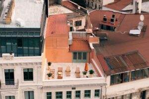 Taman rooftop apartemen minimalis dengan tanaman sukulen palem dan view kota metropolitan